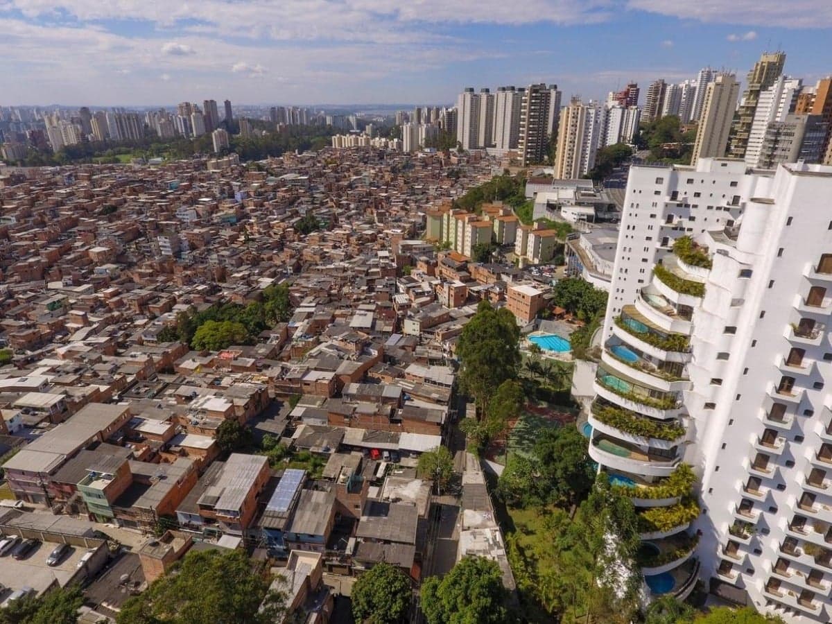 Contraste socioeconômico urbano entre um edifício de luxo e uma comunidade - Foto: iStock