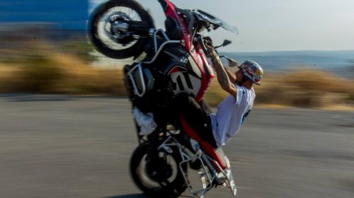 pessoa praticando wheeling conhecido como dar grau de moto