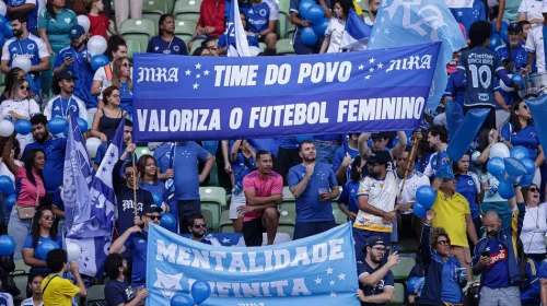 torcedores do Cruzeiro Esporte Clube exibindo faixas de apoio ao time e ao futebol feminino